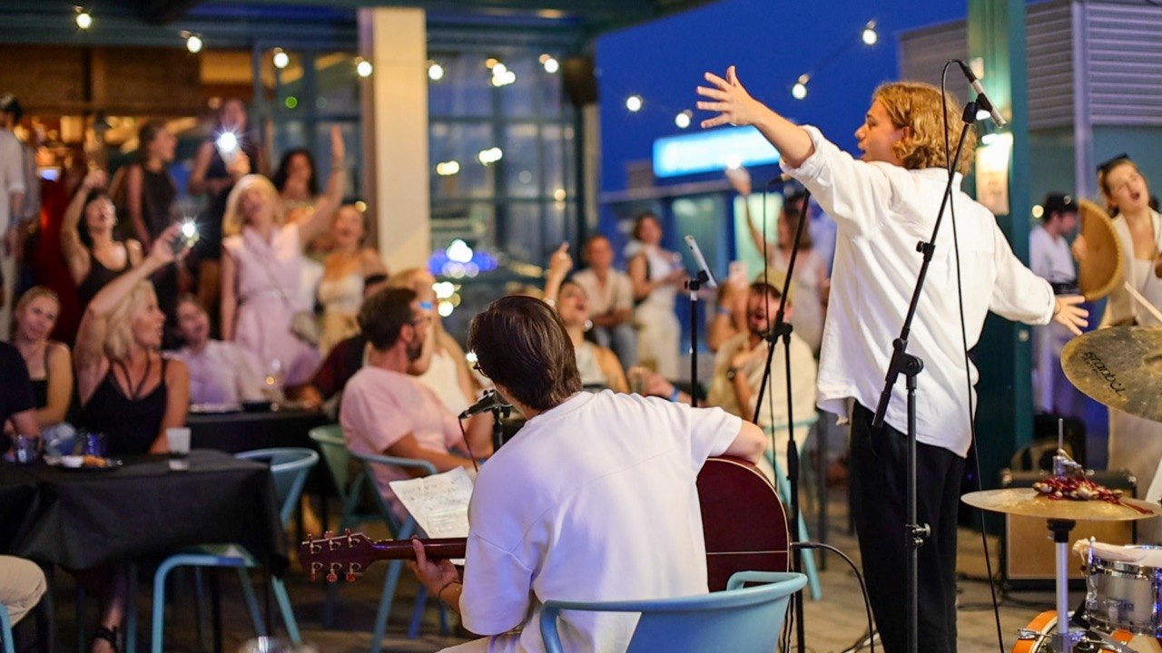 Acoustic performers and guests singing together during a [nɛbó:] evening
